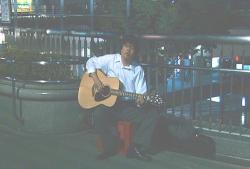 街でギターを弾く米沢
