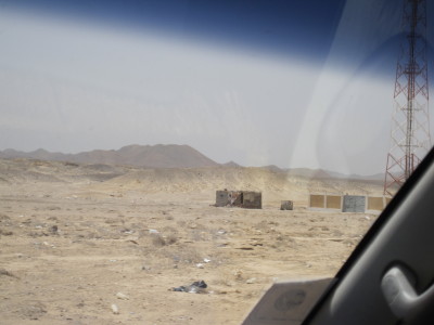 アンテナのそばにある砂漠の中の一軒家　