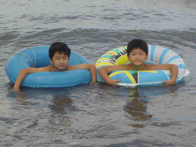 浮き輪をつけて海水浴する子供達