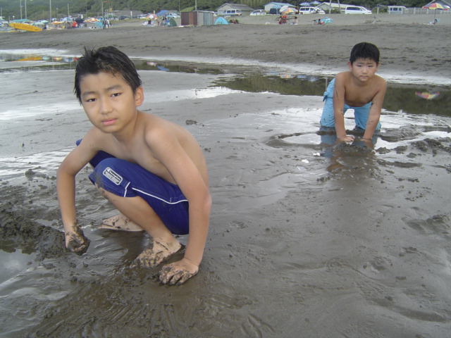 浜辺で砂遊びする子供達